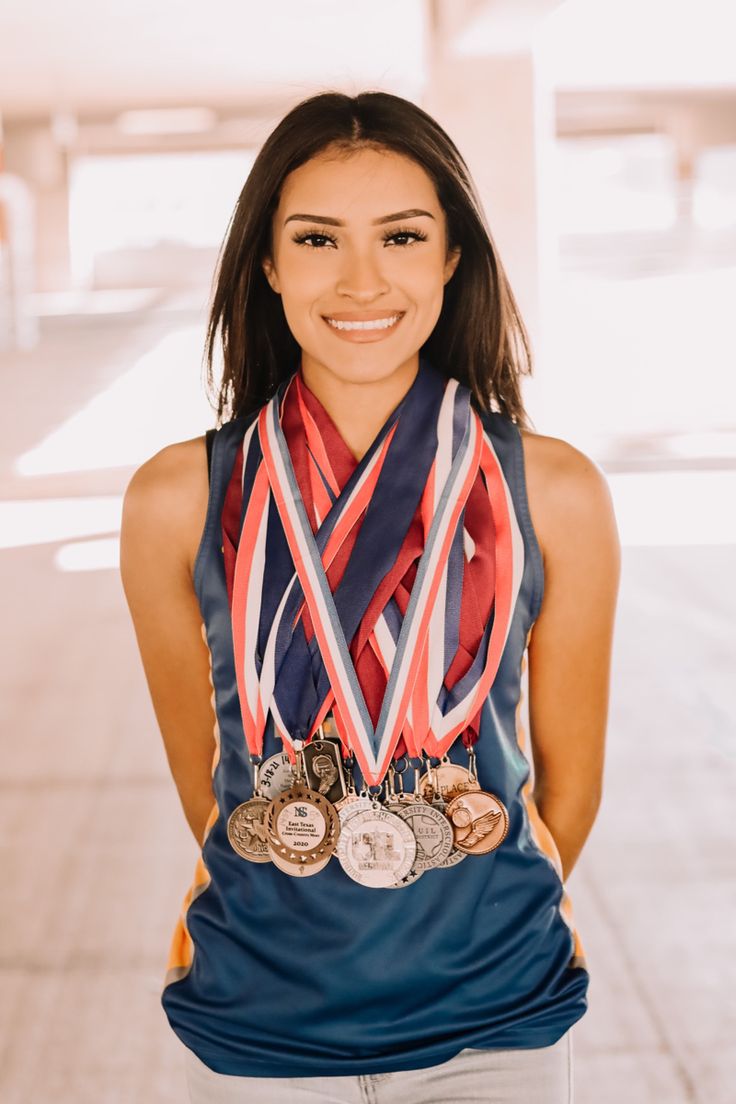 a woman with medals on her neck posing for the camera