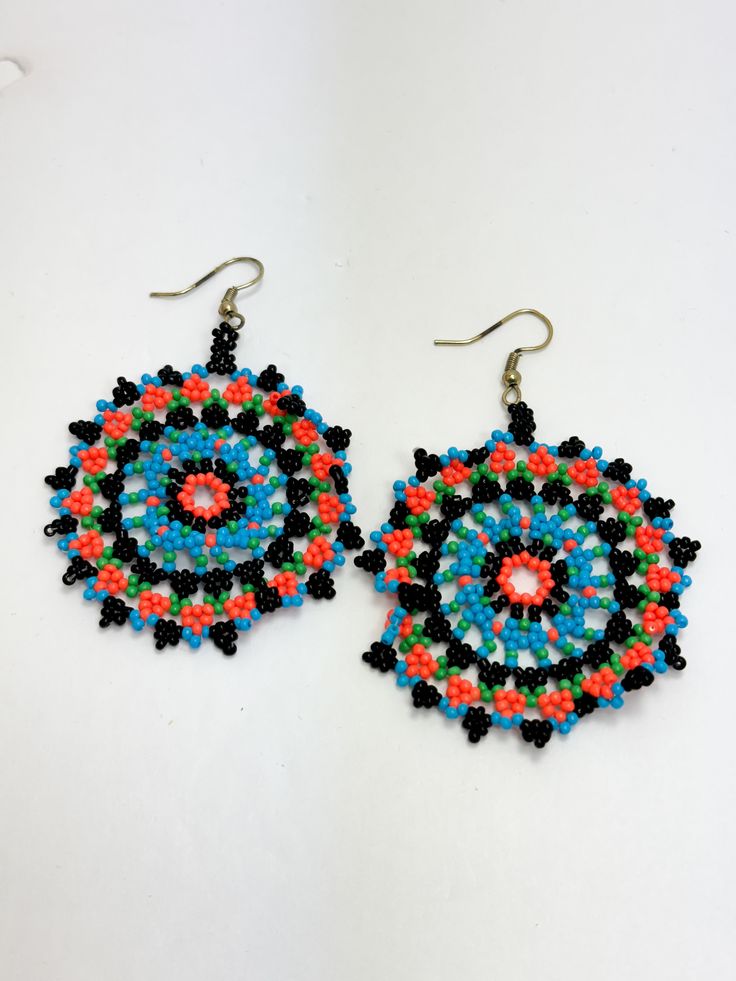 Beaded disc earrings. Lightweight. Colors: Turquoise, black, orange, and green. Size: 2.25 Turquoise Earrings With Black Round Beads, Multicolor Circular Beaded Earrings With Ear Wire, Multicolor Beaded Circle Earrings, Black Beaded Drop Earrings With Large Beads, Black Large Beaded Drop Earrings, Black Earrings With Colorful Beads, Black Round Earrings With Colorful Beads, Multicolor Round Beaded Earrings, Black Earrings With Large Round Beads