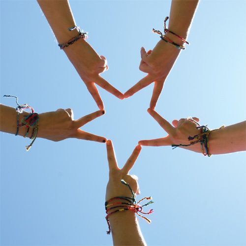 several people holding their hands in the shape of a star with string attached to them