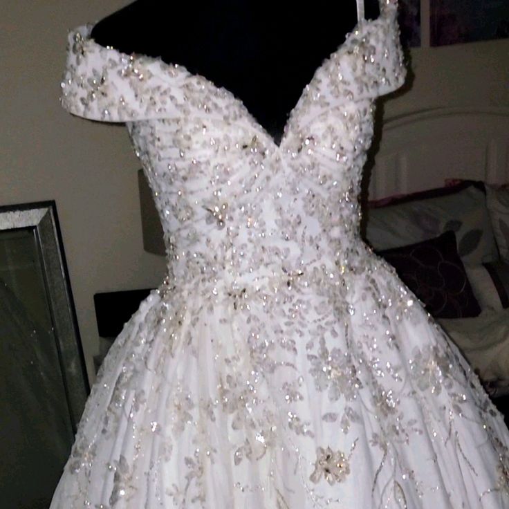 a white wedding dress on display in front of a mirror