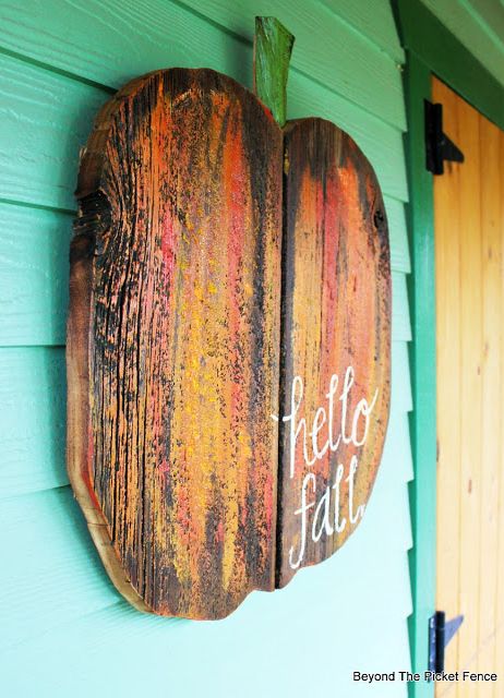 a wooden sign hanging on the side of a green building that says hello faltt