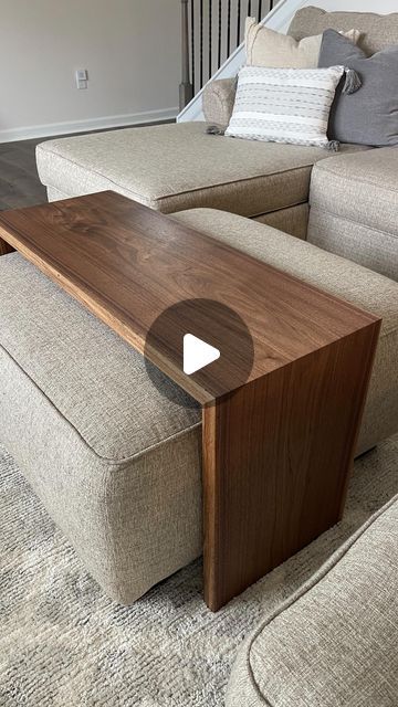 a living room with couches and a coffee table on the floor in front of stairs