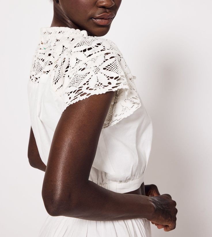 Made of lace and cotton luxe, the Teresa Blouse is the perfect warm weather sustainable blouse. It features a scoop neck and elegant lace details. Made of lace and cotton luxe Ethically Handmade in India Bra friendly Relaxed fit Scoop neck Crop length Partially lined Short sleeve blouse Sleeves and yoke are lace Functional rouleaux tie tunneled at neckline Center front button down placket Encased elastic at back waistband Hand wash cold, lay flat to dry, or dry clean Awar is 5'10" and is wearing Summer Blouses For Women, Crochet Cover Up, Romper And Jacket, Summer Blouses, New Arrival Dress, Hat Shop, Scarf Hairstyles, Ethical Fashion, Short Sleeve Blouse