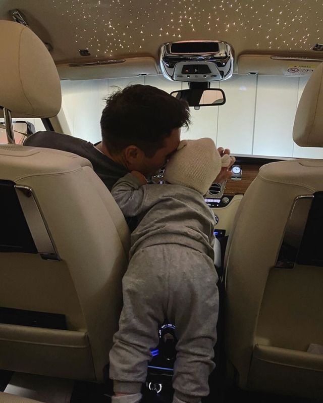 a little boy laying down in the back seat of a car