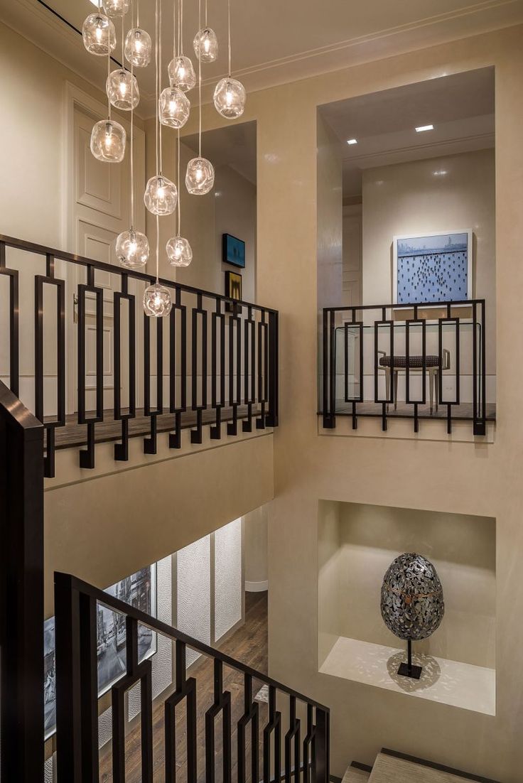 a staircase with chandelier and glass balls hanging from the railings above it