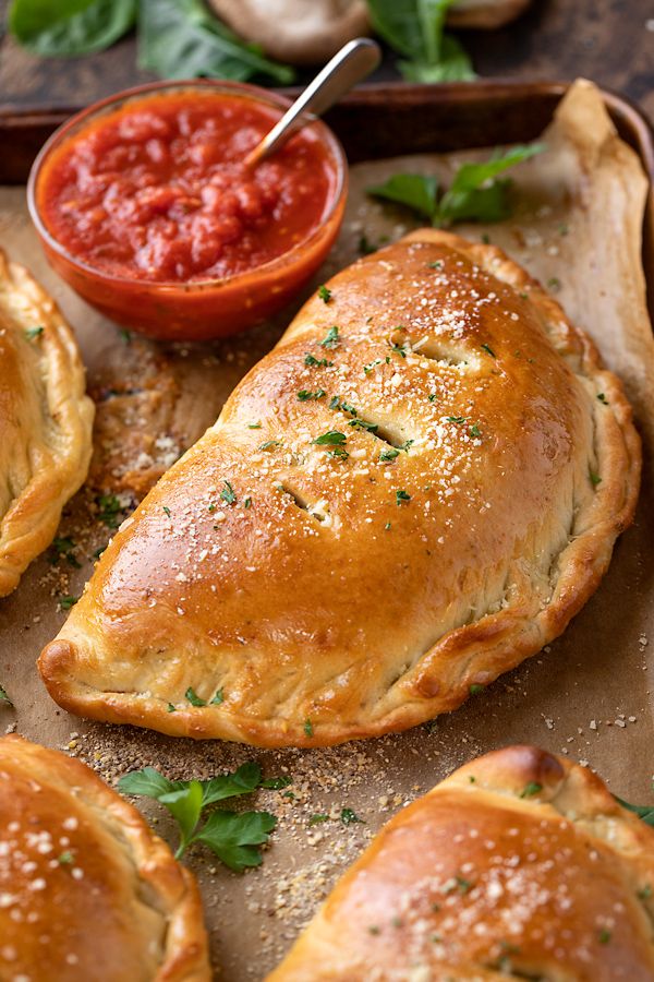 baked bread rolls on a baking sheet with dipping sauce