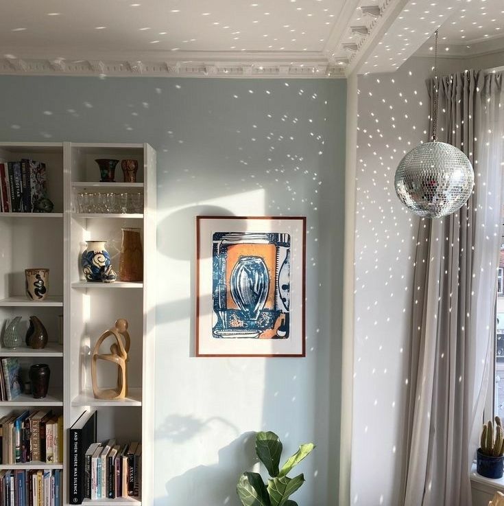 a living room filled with lots of furniture and bookshelves next to a window