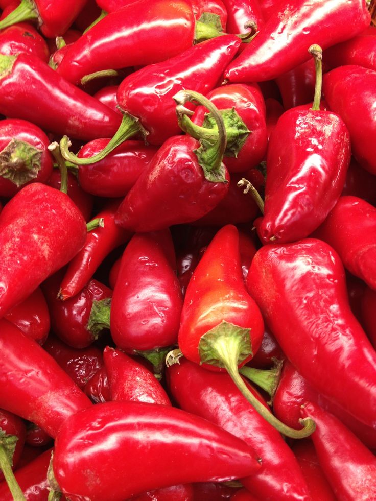 a pile of red peppers sitting next to each other