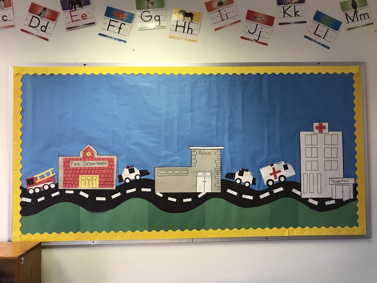 a bulletin board with cars, trucks and houses on it in front of a classroom wall