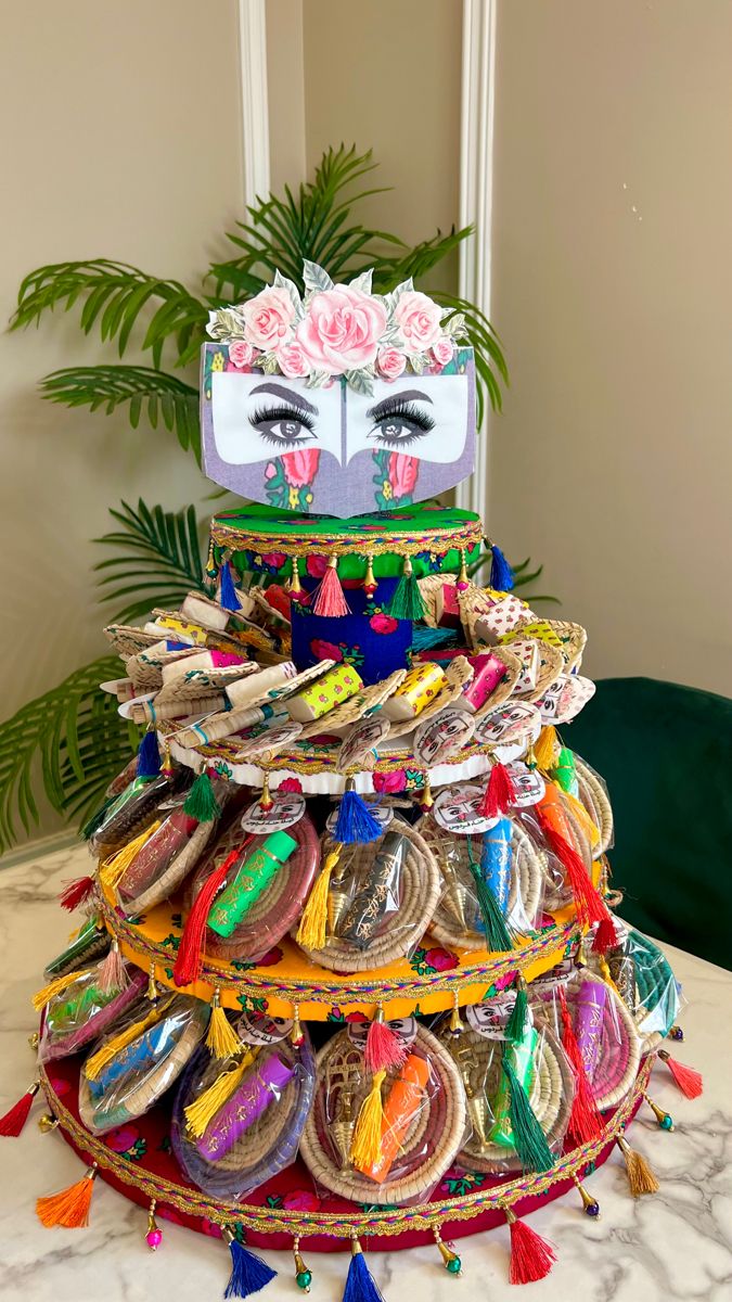 a stack of colorful shoes on top of a table next to a potted plant