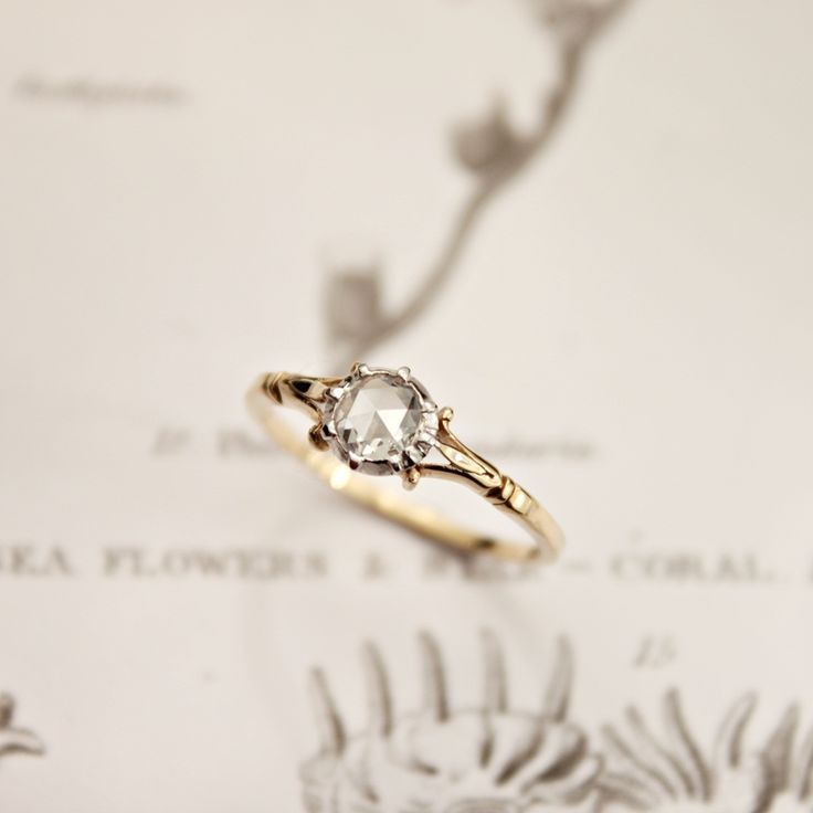 an engagement ring sitting on top of a piece of paper