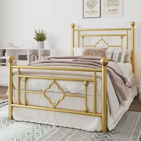 a bed with gold metal frame and headboard in a white room next to a window