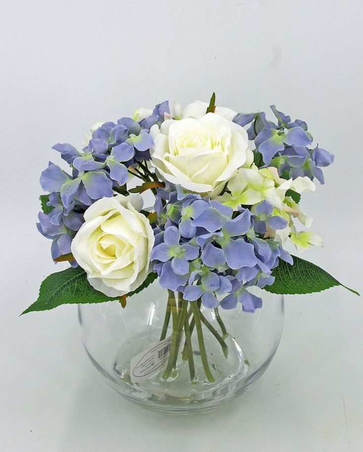 a vase filled with white and blue flowers