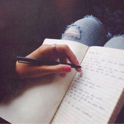 a person writing in a notebook with a pen on their lap and the words la vida written in spanish