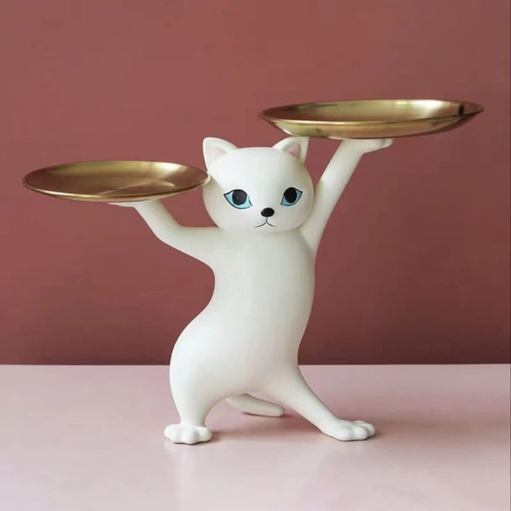 a white cat holding two gold plates on its back