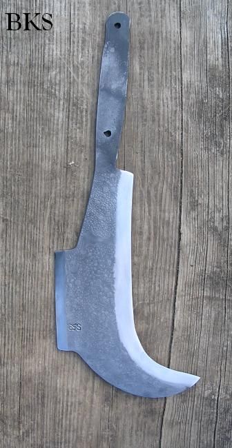 a knife that is sitting on top of a wooden table, with the handle missing