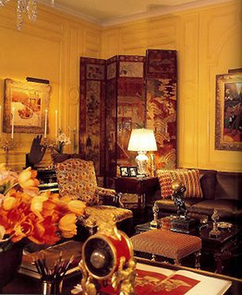 a living room filled with lots of furniture and flowers in vases on the table