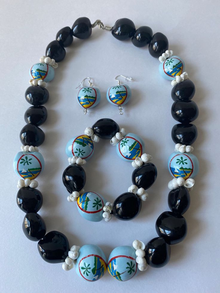 Beautiful handmade jewelry set consisting of a necklace, bracelet and earrings. They are made up of black kukui nuts, some of which are hand painted with the Guam seal and white mongo shells. The bracelet is on an elastic band which makes it expandable. The earrings come on silver hooks and the necklace has a sturdy silver clasp. Guam Seal, Handmade Jewelry Set, Kukui Nut, Money Lei, Red Butterfly, Knoxville Tn, Shell Jewelry, You Are Amazing, Star Necklace