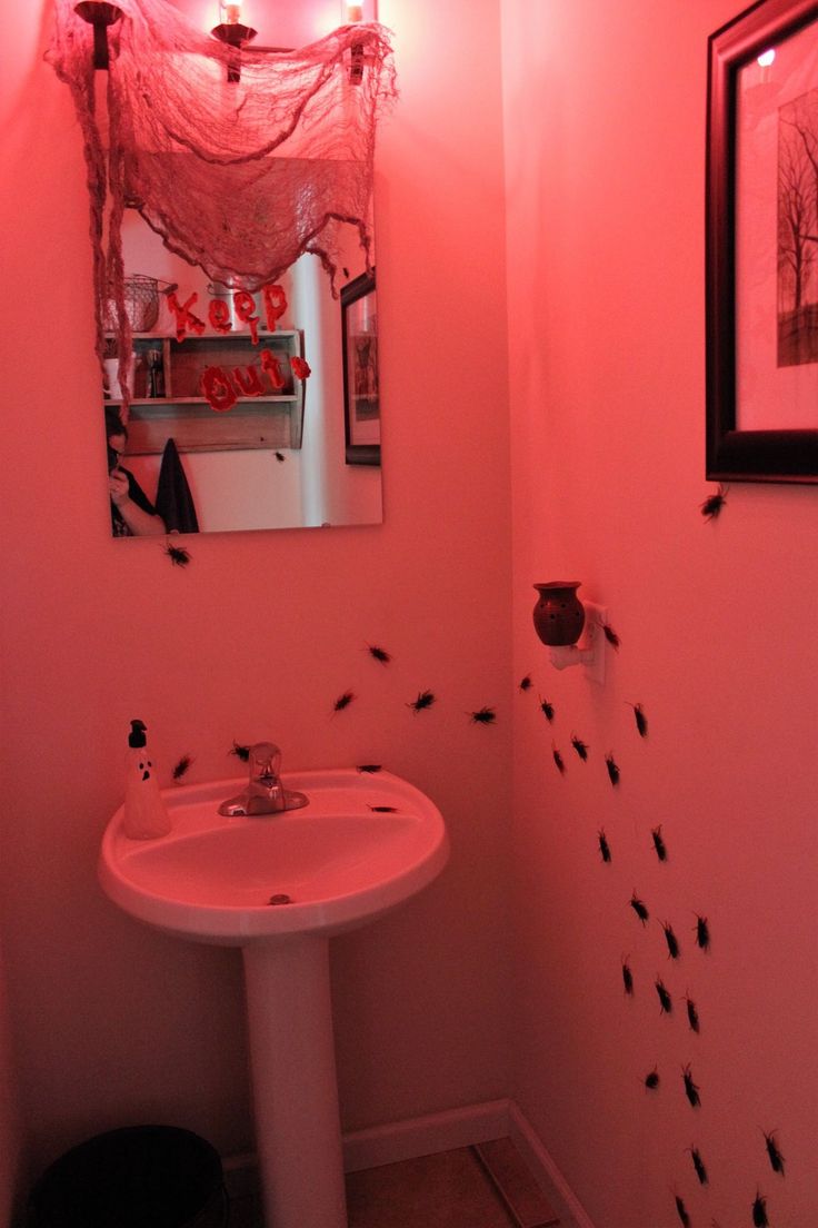 a bathroom with pink walls and black bugs on the wall in front of the sink