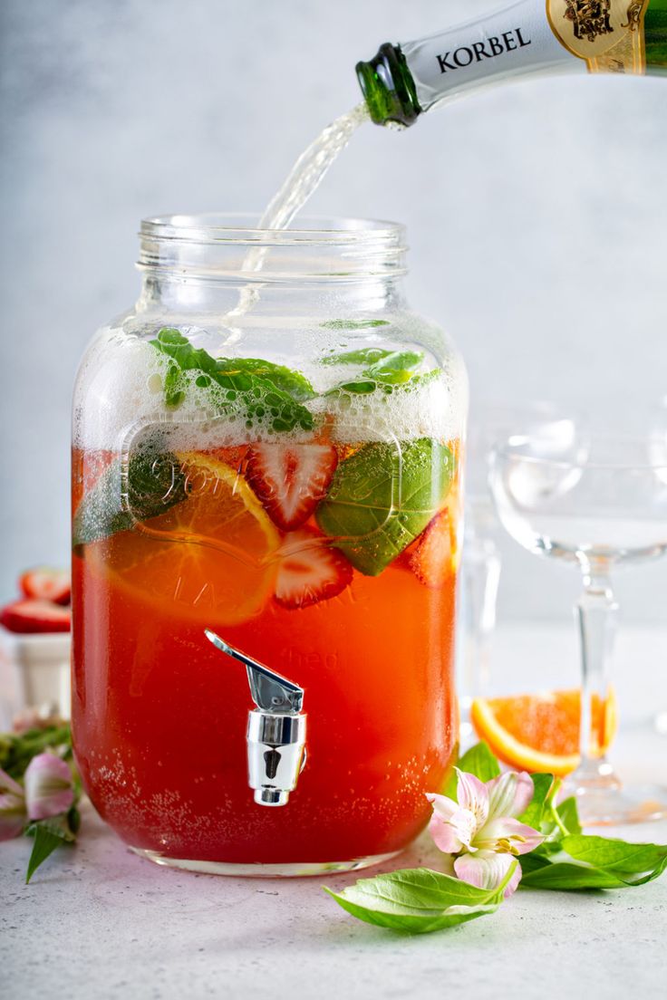 a glass filled with liquid and some fruit