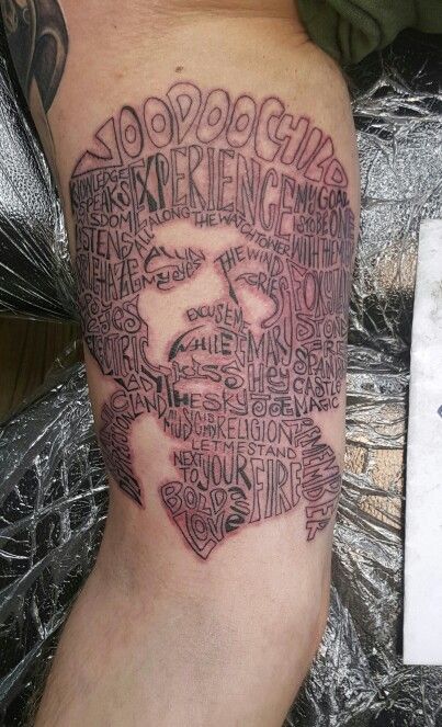 a man's arm with words written in the shape of a face on it