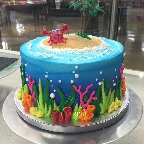 there is a blue cake decorated with an ocean scene on the bottom and under it