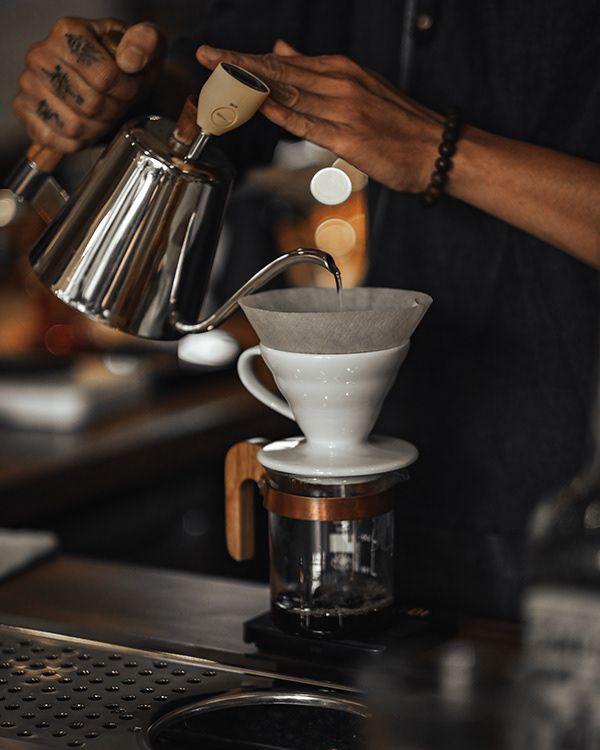 a person pours coffee into a cup