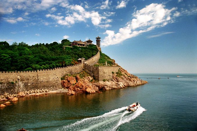 a boat traveling down the water near a castle