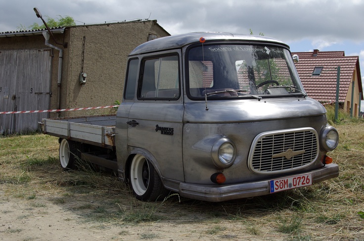 an old silver truck parked in front of a house