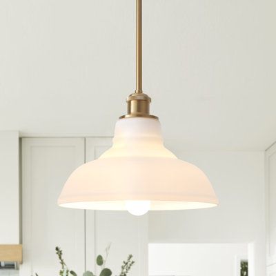 a kitchen with white cabinets and a large light hanging from the ceiling over the island