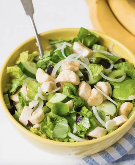 a yellow bowl filled with lettuce and chicken