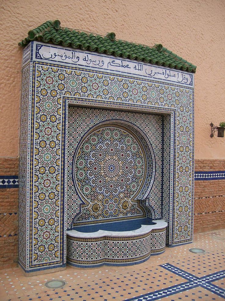 an intricately designed fountain in the middle of a tiled area with blue and white tiles