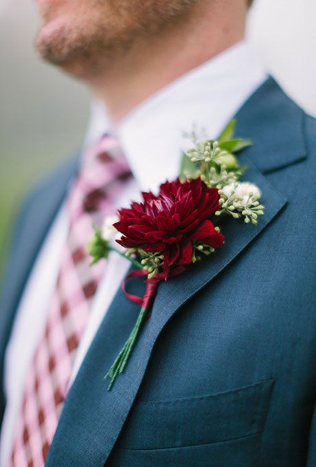 a man in a suit with a red flower on his lapel