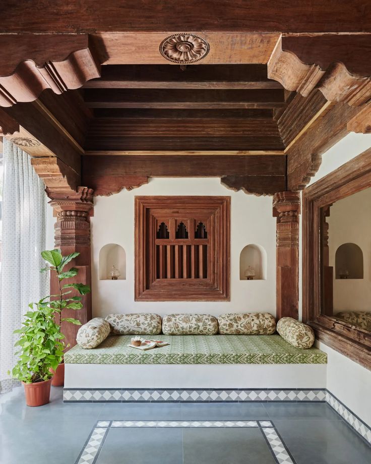 a room with a couch, mirror and potted plant