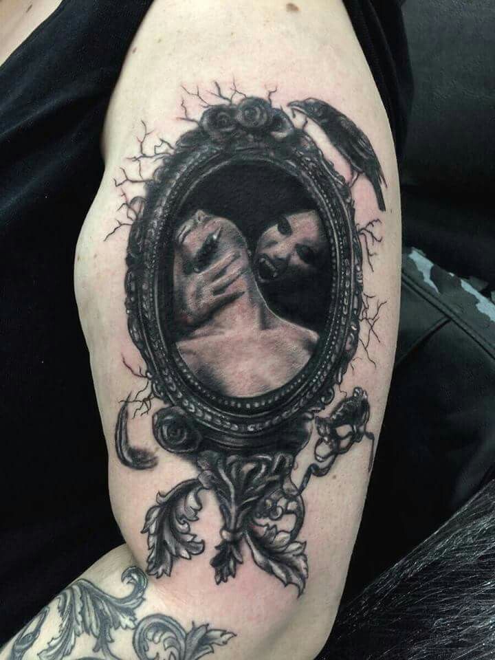 a man's arm with a mirror on it and a monkey in the reflection