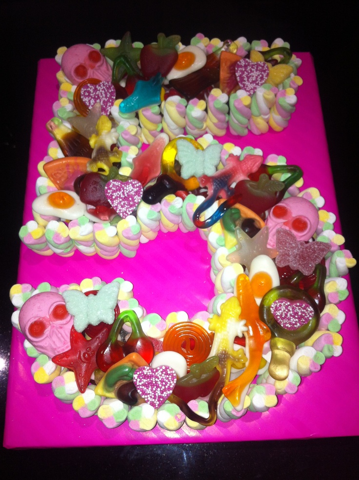 there is a cake made to look like the letter c with many candies on it