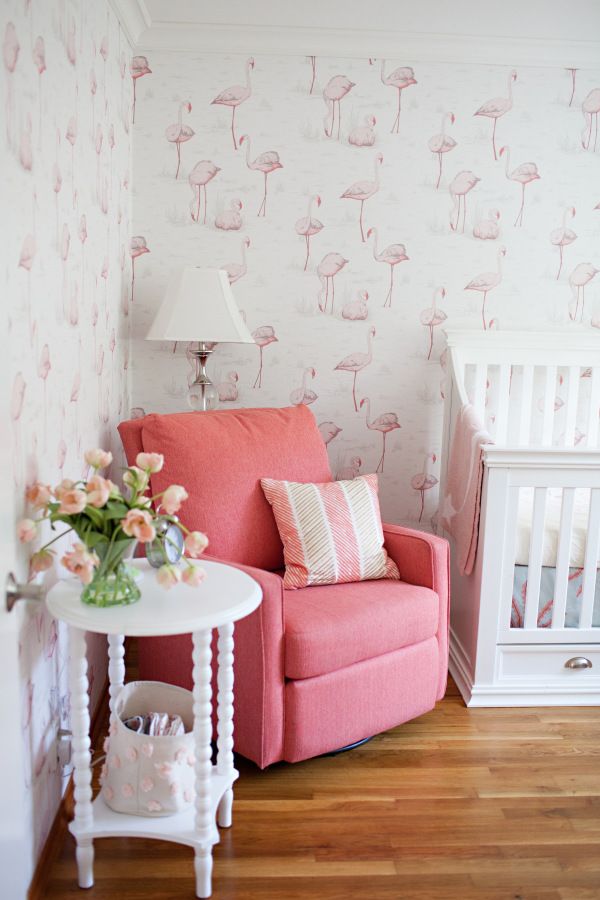 a baby's room with pink furniture and wallpaper