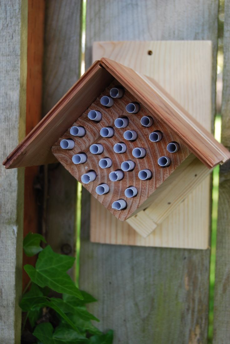 a wooden bird house with holes in the roof