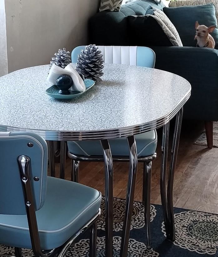 a table with chairs and a pine cone on it in front of a blue couch