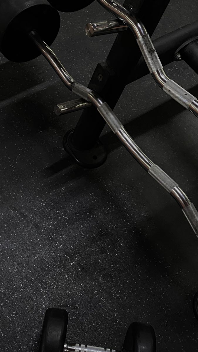 a close up of a barbell with two black dumbs on the ground in front of it