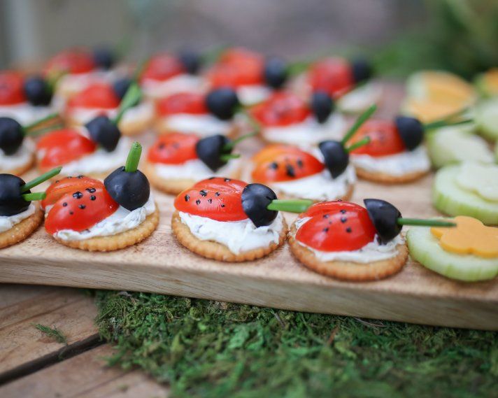 small appetizers are arranged on a wooden platter