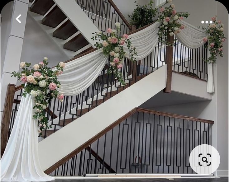 a staircase decorated with flowers and white drapes