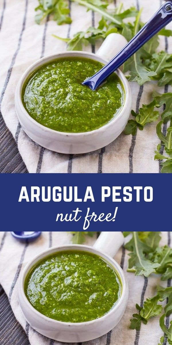 two white bowls filled with pesto next to some parsley on a tablecloth