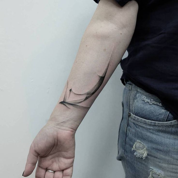 a person with a tattoo on their arm holding onto the wrist and pointing at something