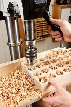 two people working with woodworking tools in a machine shop, one is using a drill and the other is using a milling head