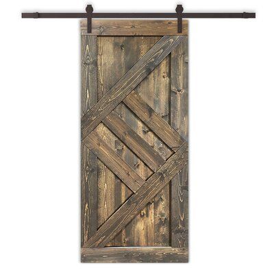 an old wooden door hanging on a metal rod with wood planks and iron bars