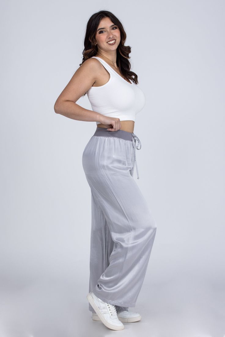 Lounging In Satin Lounge Pants by PJ Harlow will have you feeling elegant day or night! These luxe satin pants feature a wide leg and ribbed waist with adjustable tie. You will feel fancy as you are lounging and sleeping at home! Made in the USA Women owned business Fabric: 75% Rayon 25% Satin Faille Contrast Measurements: Rise (Size M): 31" Inseam (Size M): 12" True To Size S 0-6 M 6-10 L 10-14 XL/1XL 14-18 Casual Satin Bottoms For Loungewear, Casual Satin Loungewear Bottoms, Satin Trousers For Loungewear, Comfortable Satin Lounge Pants, Satin Lounge Pants With Elastic Waistband, Satin Wide Leg Pants For Loungewear, Satin Pants With Elastic Waistband For Loungewear, Elegant Wide Leg Bottoms For Pajama Party, Satin Wide-leg Loungewear Bottoms