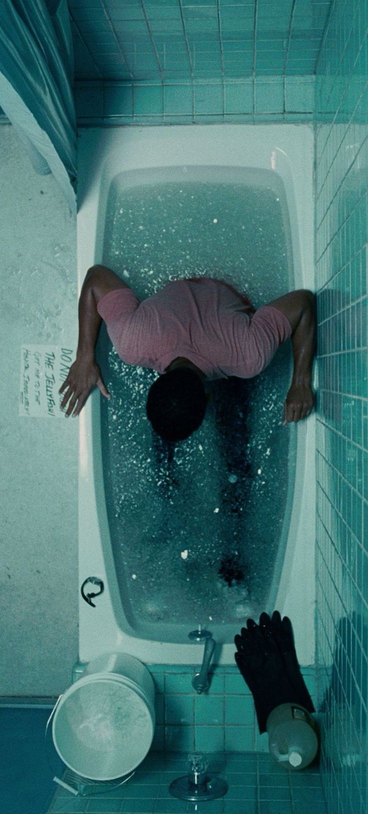 a man is floating in the bathtub with his head above the water and hands on the floor