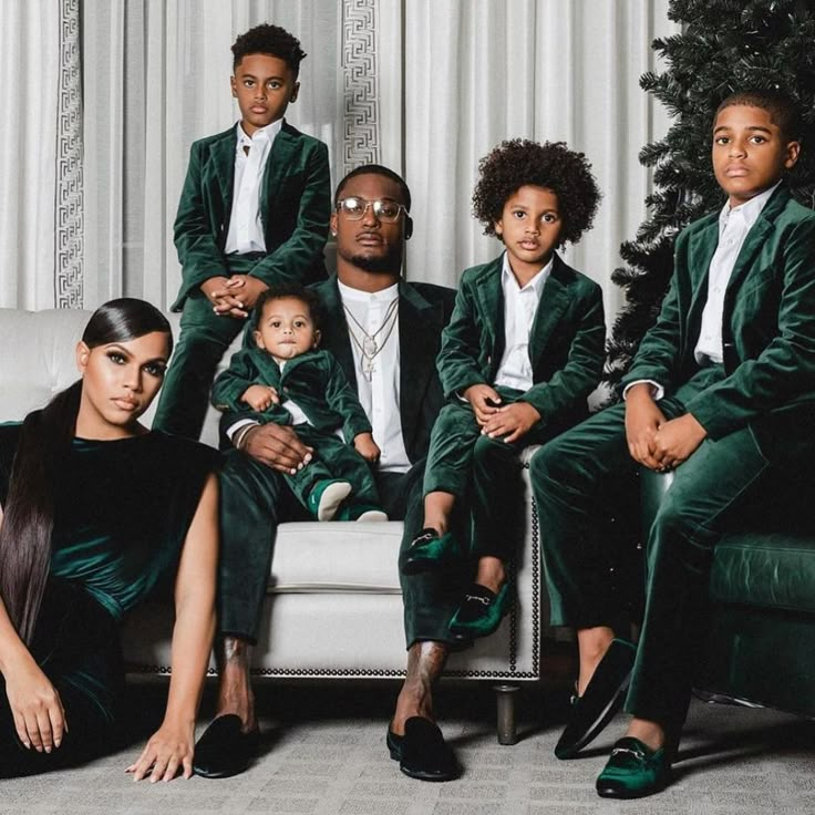 a group of people sitting on top of a couch in front of a christmas tree