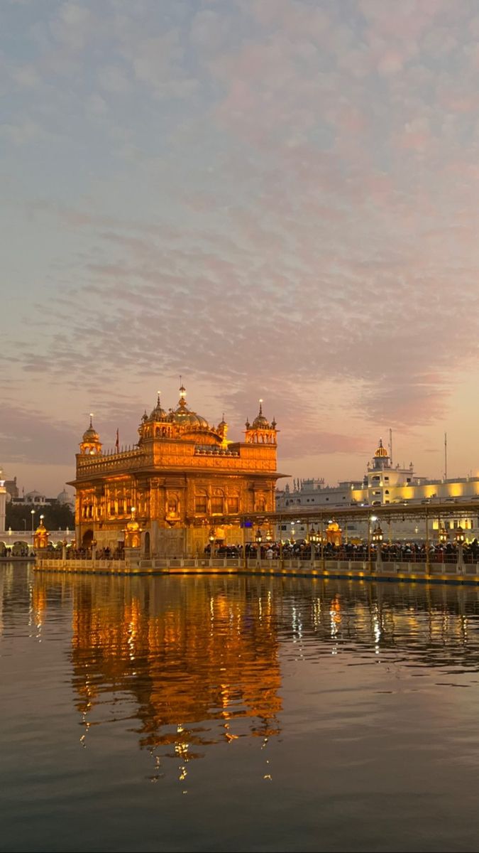 the golden temple in amrit, india is reflected in the water at sunset or dawn